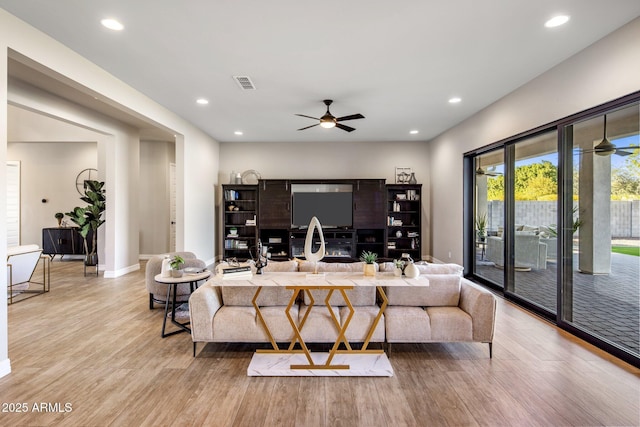 living room with ceiling fan and light hardwood / wood-style flooring