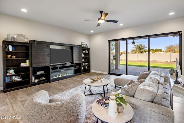 living room with light hardwood / wood-style flooring and ceiling fan