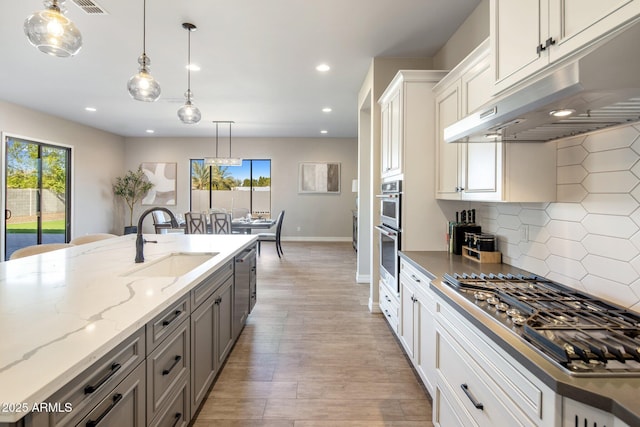 kitchen with white cabinetry, tasteful backsplash, dark stone counters, pendant lighting, and stainless steel appliances