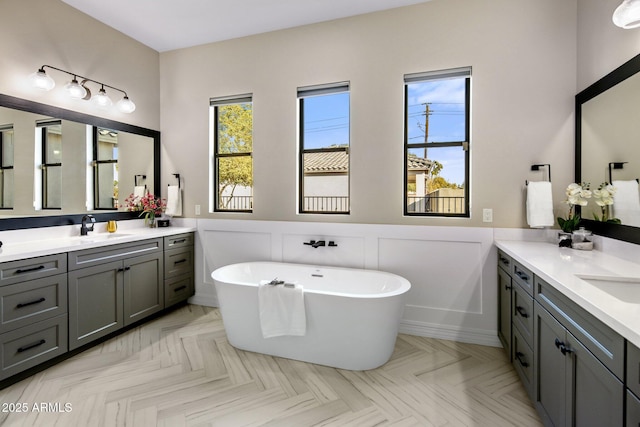 bathroom featuring vanity, a tub, and parquet floors