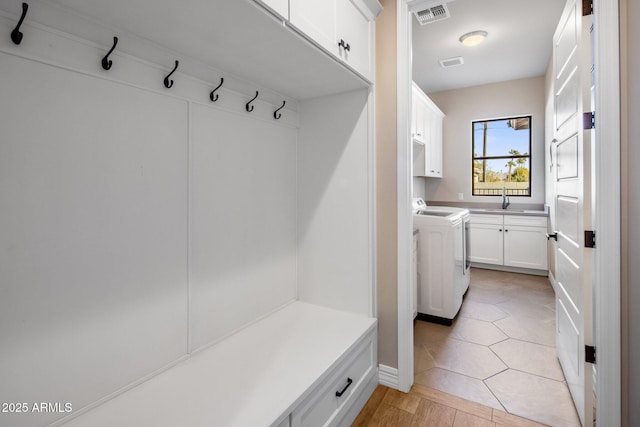 mudroom with sink, washing machine and dryer, and light tile patterned floors