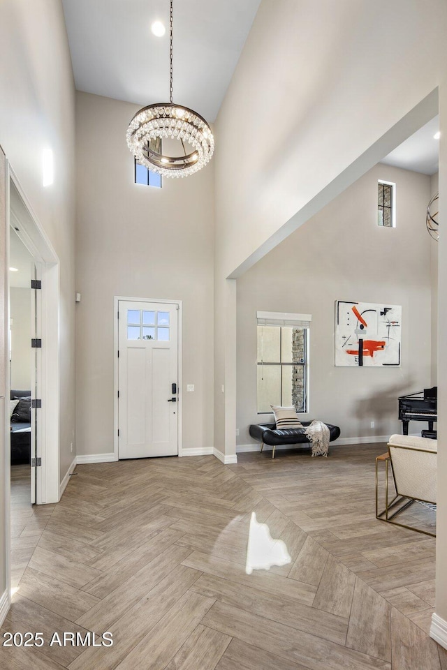 foyer featuring light parquet floors, plenty of natural light, and a towering ceiling