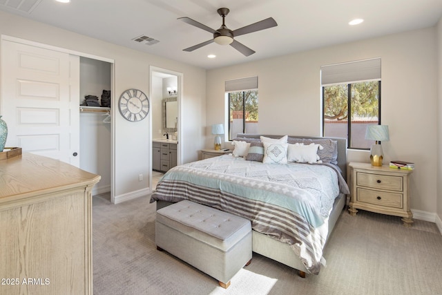 bedroom featuring ensuite bathroom, sink, light carpet, a closet, and ceiling fan