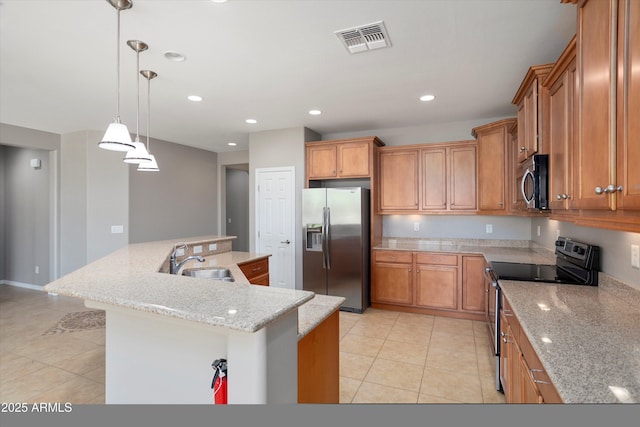 21532 N 262nd Ln, Buckeye, AZ 85396 - kitchen with stainless steel appliances, brown cabinetry, light tile patterned flooring, a sink, and recessed lighting