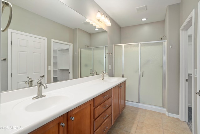 21532 N 262nd Ln, Buckeye, AZ 85396 - full bath featuring a stall shower, a walk in closet, double vanity, tile patterned floors, and baseboards