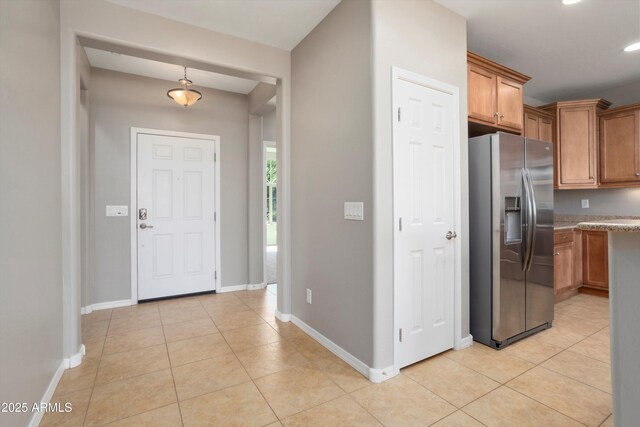 21532 N 262nd Ln, Buckeye, AZ 85396 - kitchen featuring stainless steel fridge, light tile patterned flooring, brown cabinets, baseboards, and recessed lighting