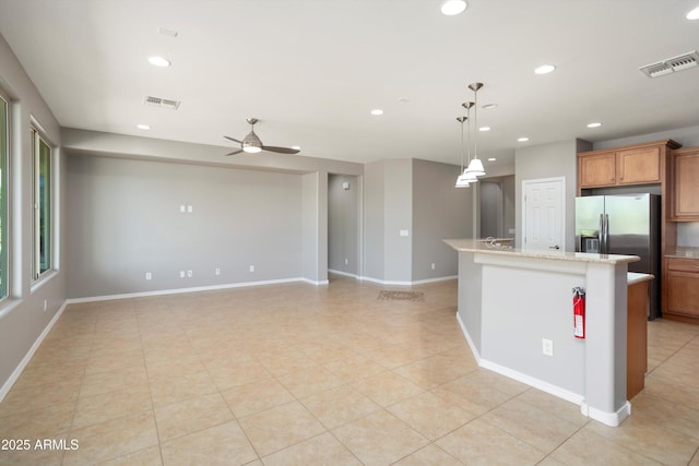21532 N 262nd Ln, Buckeye, AZ 85396 - kitchen with a ceiling fan, recessed lighting, brown cabinets, a kitchen island, and light tile patterned floors