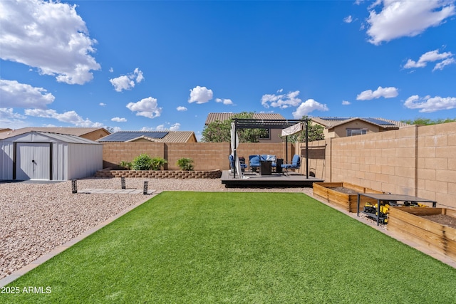 view of yard with an outdoor hangout area, a storage unit, an outbuilding, and a fenced backyard