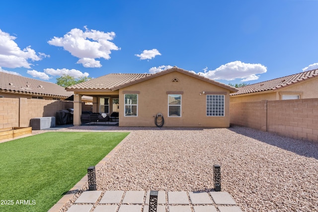 back of house featuring a lawn, a fenced backyard, a patio area, and stucco siding