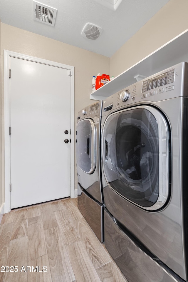 laundry area featuring washer and dryer, laundry area, and visible vents