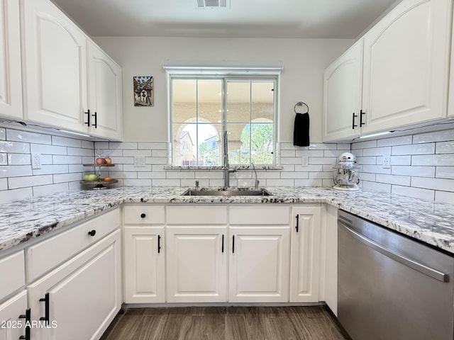 kitchen with dark wood-style flooring, dishwasher, white cabinetry, and light stone countertops