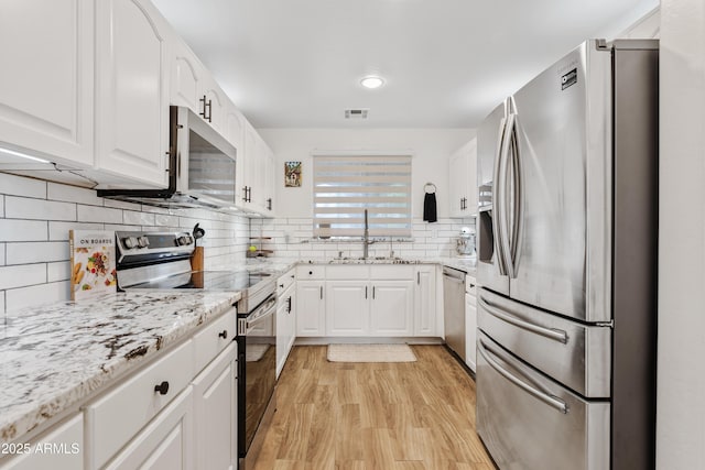 kitchen featuring visible vents, light wood-type flooring, a sink, stainless steel appliances, and white cabinetry