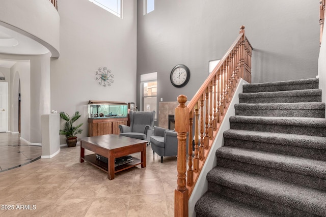 17005 S Coleman St, Phoenix, AZ 85045 - living area with stairway, light tile patterned floors, baseboards, arched walkways, and a towering ceiling