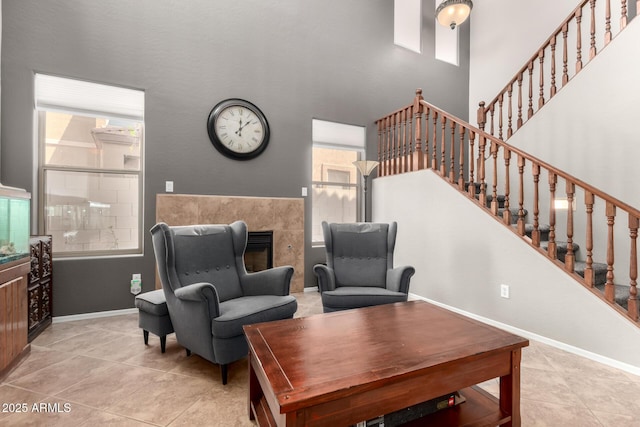 17005 S Coleman St, Phoenix, AZ 85045 - tiled living area featuring baseboards, a fireplace, a towering ceiling, and stairway