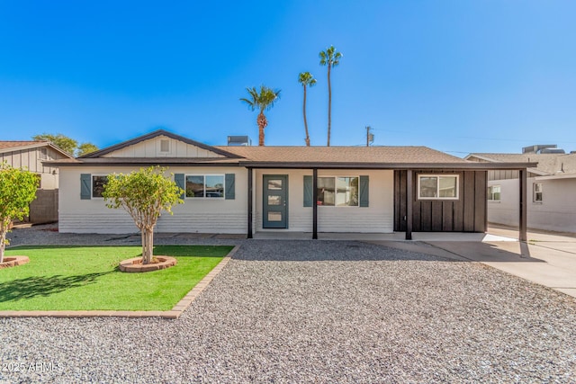 single story home featuring board and batten siding and a front yard