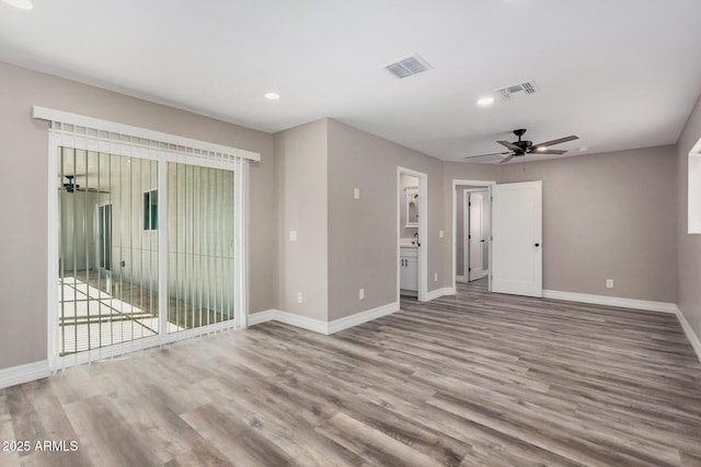 spare room with visible vents, baseboards, and wood finished floors