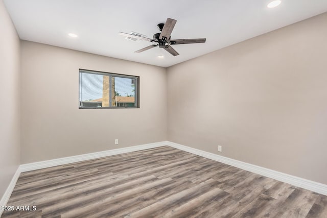 spare room featuring baseboards and wood finished floors