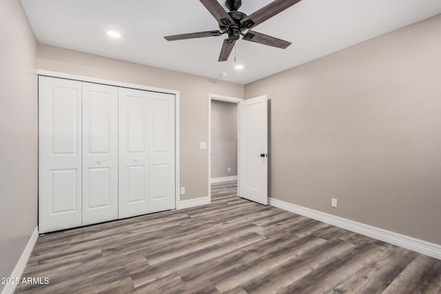 unfurnished bedroom featuring baseboards, recessed lighting, wood finished floors, a closet, and a ceiling fan