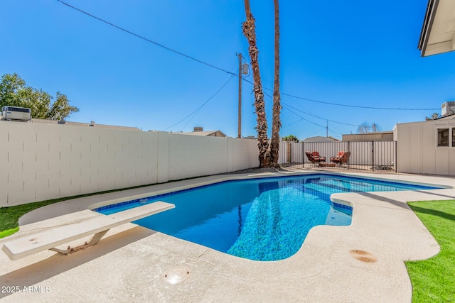 view of swimming pool featuring a patio, a diving board, a fenced backyard, and a fenced in pool