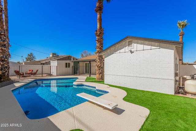 view of pool featuring a diving board, a patio area, a yard, and fence