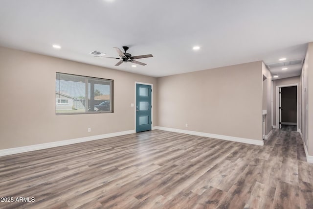 spare room featuring visible vents, recessed lighting, baseboards, and wood finished floors