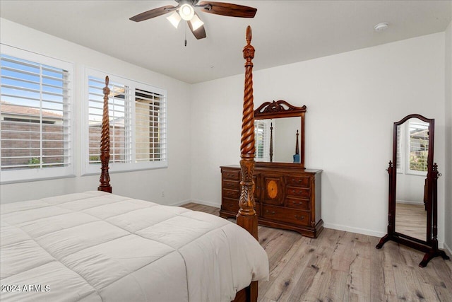 bedroom featuring ceiling fan, hardwood / wood-style flooring, and multiple windows