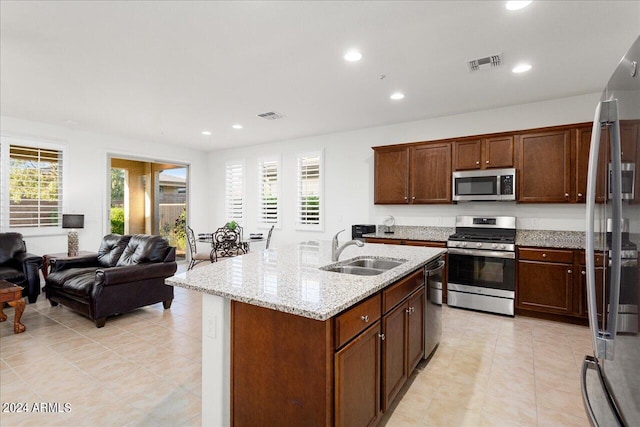 kitchen featuring a kitchen island with sink, plenty of natural light, stainless steel appliances, and sink