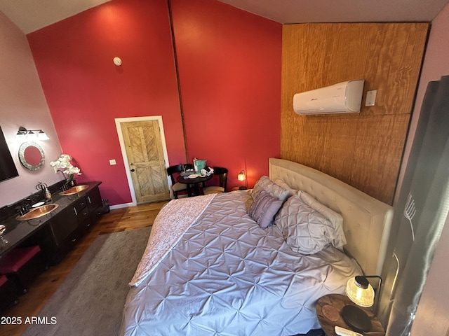 bedroom featuring high vaulted ceiling, a wall mounted air conditioner, and wood finished floors