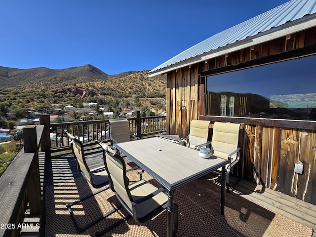 deck with outdoor dining area and a mountain view