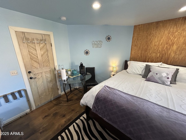 bedroom with baseboards, wood finished floors, and recessed lighting