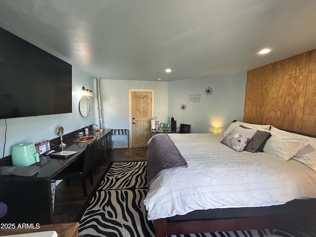 bedroom featuring a sink, wood finished floors, and recessed lighting