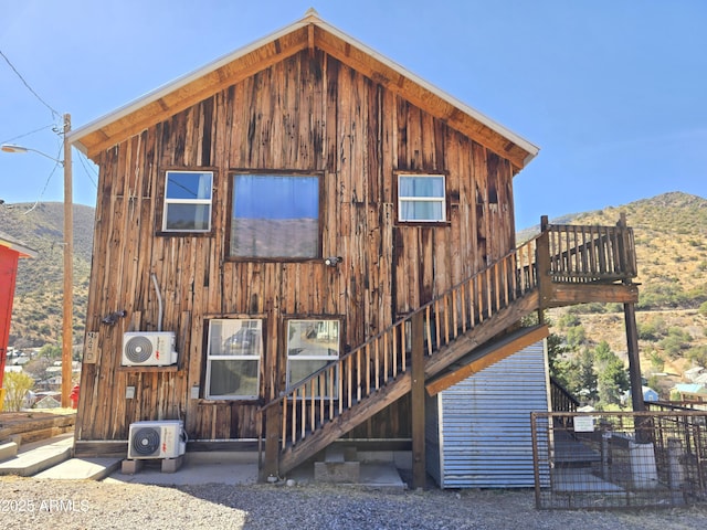 rear view of property featuring stairs, ac unit, and a mountain view