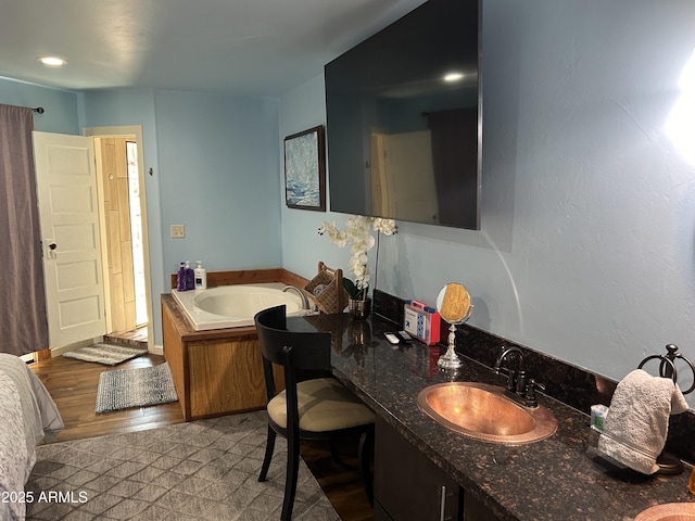 bathroom with a garden tub and vanity