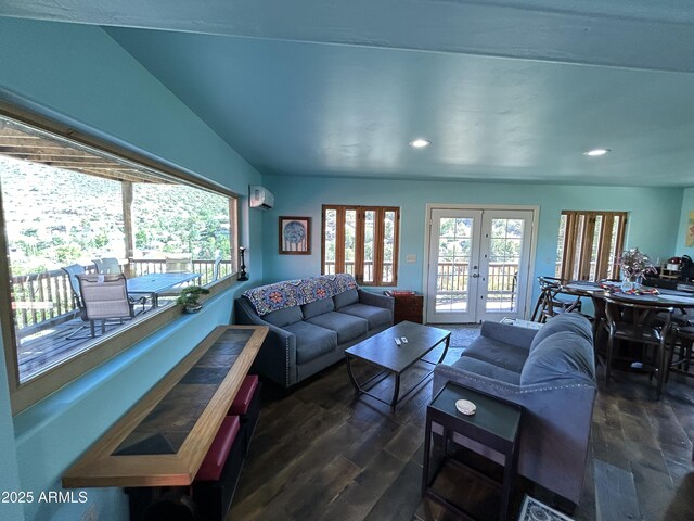 living area featuring a healthy amount of sunlight, a wall mounted AC, dark wood-style floors, and french doors