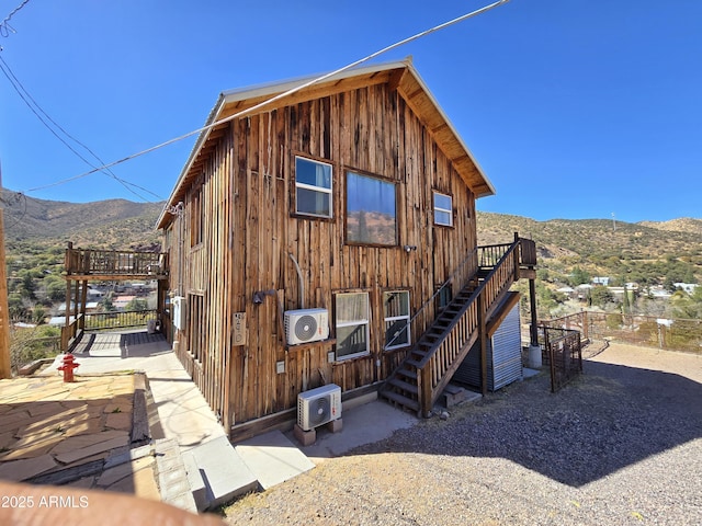 view of front of property featuring ac unit, a deck with mountain view, and stairs