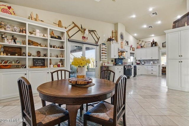 dining space featuring lofted ceiling, visible vents, and a wealth of natural light