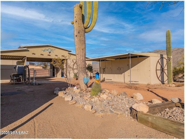 view of front of property with stucco siding, an outbuilding, and a shed