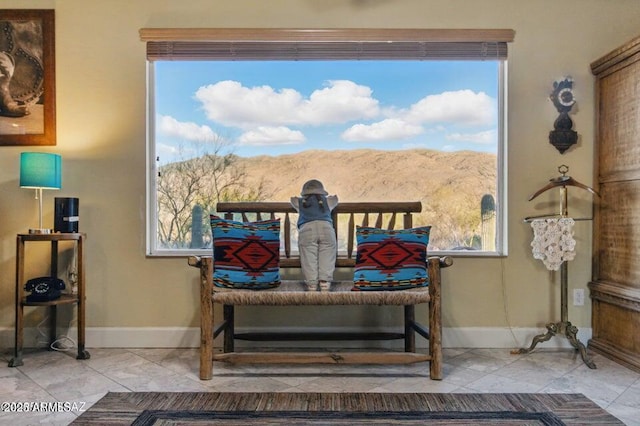 dining room featuring baseboards, marble finish floor, and a mountain view
