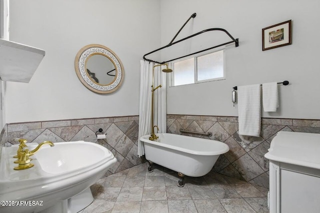 bathroom with tile walls, a soaking tub, a wainscoted wall, and a shower with curtain