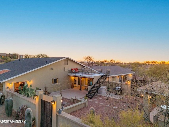 view of front of home featuring stairway, a gate, a fenced front yard, a patio, and a deck