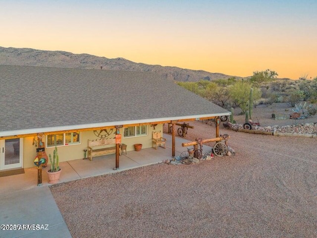 back of house featuring a patio area, a mountain view, and stucco siding