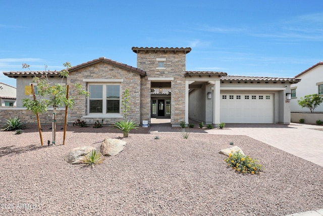20775 W Rattler Rd, Buckeye, AZ 85396 - mediterranean / spanish home with stucco siding, stone siding, a tiled roof, decorative driveway, and a garage