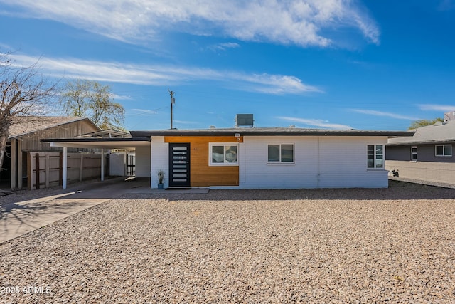 view of front of property featuring fence, a carport, and concrete driveway