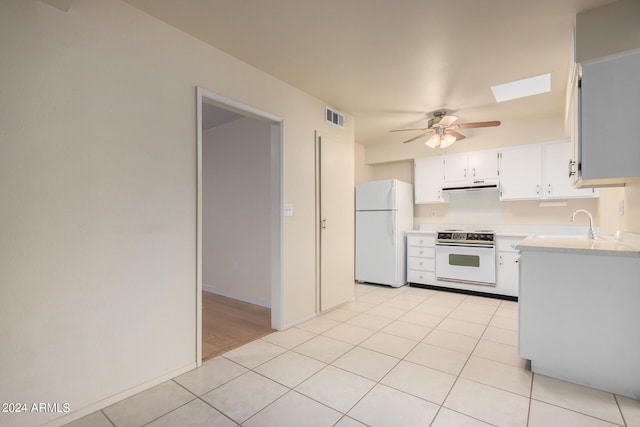 kitchen featuring white appliances, white cabinetry, sink, ceiling fan, and light tile patterned floors