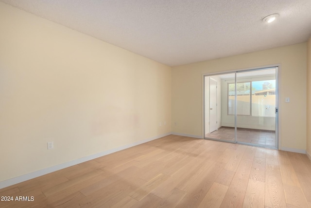 empty room featuring light hardwood / wood-style floors and a textured ceiling