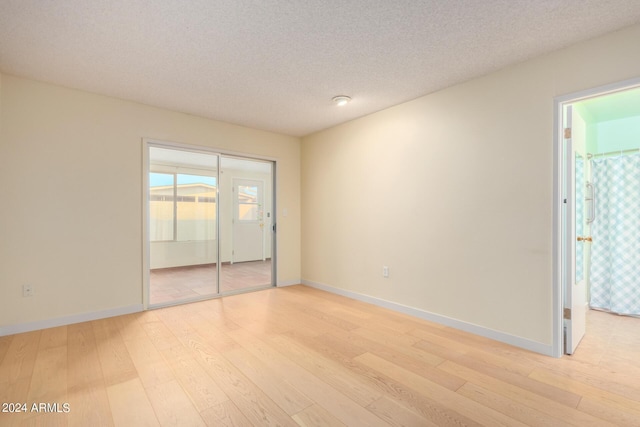 empty room featuring light hardwood / wood-style floors and a textured ceiling