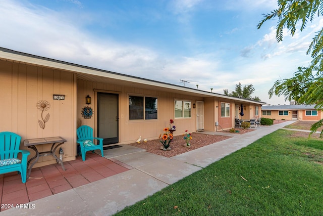 ranch-style home with a front yard and a patio