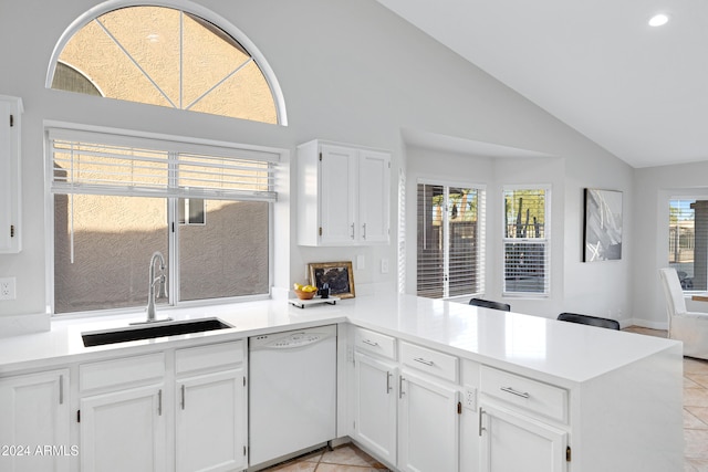 kitchen featuring dishwasher, white cabinets, sink, vaulted ceiling, and kitchen peninsula