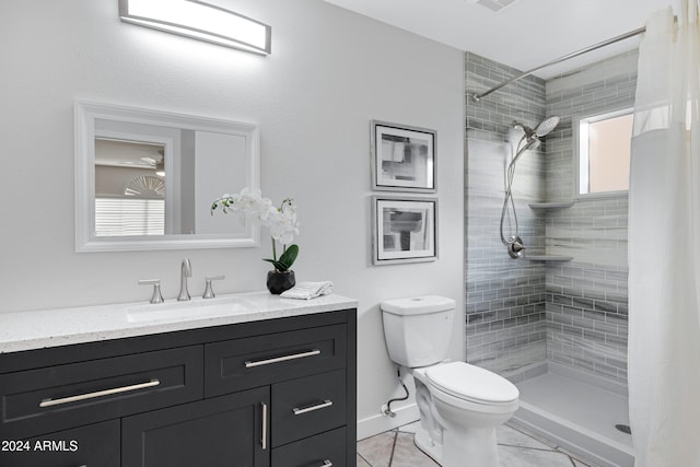 bathroom featuring tiled shower, vanity, and toilet