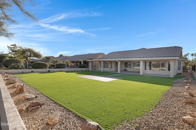 back of property featuring a yard and a patio